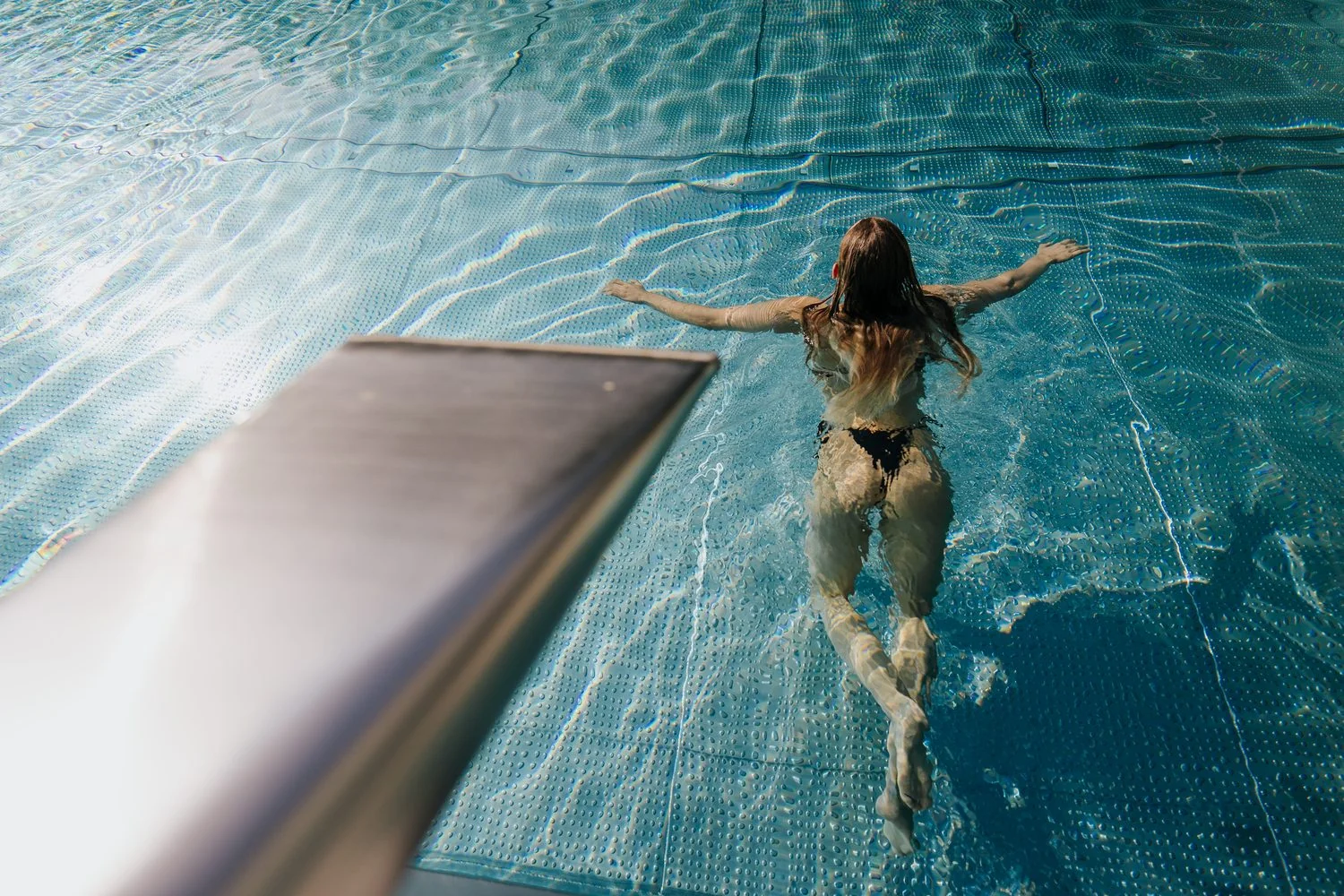 Schwimmerin im Becken, von oben fotografiert
