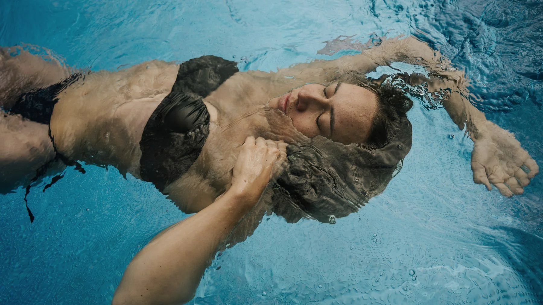 Person schwerelos im Wasser treibend, von oben fotografiert